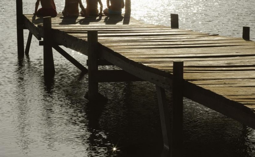 Kids sitting at the end of dock