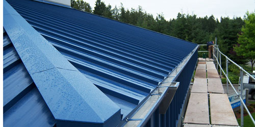 Commercial roof retrofits with roof gutters, leader heads and hidden fasteners.