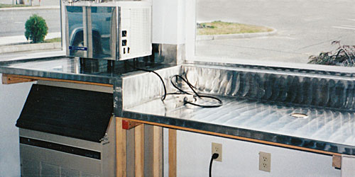 Custom-designed and fabricated countertops at a local Tumwater, Washington, espresso stand consisting of stainless steel with random-sanded design.